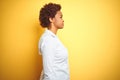 African american business woman over isolated yellow background looking to side, relax profile pose with natural face and Royalty Free Stock Photo