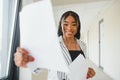 African american business woman standing, office hall with documents Royalty Free Stock Photo