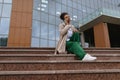 african american business woman talking on a mobile phone while sitting on the steps in front of an office building Royalty Free Stock Photo