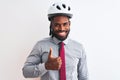 African american businessman with braids wearing bike helmet over isolated white background doing happy thumbs up gesture with Royalty Free Stock Photo