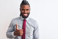 African american businessman with braids wearing tie standing over isolated white background doing happy thumbs up gesture with Royalty Free Stock Photo