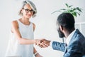 african american businessman and cheerful caucasian businesswoman shaking hands Royalty Free Stock Photo
