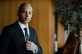 African american businessman in elegant formal wear looking at camera in blurred lobby of business center Royalty Free Stock Photo