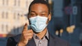 African American businessman ethnic man male guy in medical face mask pointing with finger hey you agree show number one Royalty Free Stock Photo