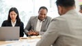 An African American businessman and his Asian secretary are in a meeting with a financial team Royalty Free Stock Photo