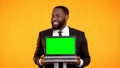African-american businessman holding prekeyed laptop and smiling, ad template