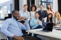 African American Businessman Leading Meeting In Creative Office, Boss Using Laptop Computer In Foreground Over Business