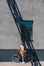 African american businessman standing with bicycle by wall under window Royalty Free Stock Photo