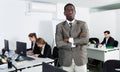 African American businessman standing at office on background with working colleagues Royalty Free Stock Photo