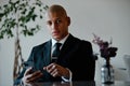 African american businessman in suit holding smartphone in lobby of business center Royalty Free Stock Photo