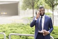 African American businessman talking on mobile phone having coffee break Royalty Free Stock Photo