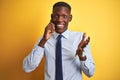 African american businessman talking on smartphone standing over isolated yellow background very happy and excited, winner Royalty Free Stock Photo