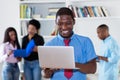 African american businessman with tie and computer and colleagues Royalty Free Stock Photo