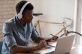 African American businessman wearing headset using laptop, working online Royalty Free Stock Photo