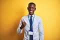 African american businessman wearing identification card over  yellow background doing happy thumbs up gesture with hand Royalty Free Stock Photo