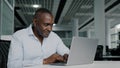 African american businessman work on laptop at office chatting online young woman trainee come to adult colleague Royalty Free Stock Photo