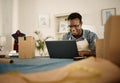 African american businessman working on his laptop. Happy tailor typing an email on his computer. Young fashion designer Royalty Free Stock Photo