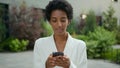 African American businesswoman chatting with mobile app outdoors ethnic girl using phone in city business woman Royalty Free Stock Photo