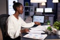 African american businesswoman checking company documents overworking at financial strategy Royalty Free Stock Photo