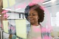 African american businesswoman looking at sticky notes on glass wall Royalty Free Stock Photo