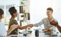 African american businesswoman and mixed race businessman shaking hands while their colleagues clap hands in support Royalty Free Stock Photo