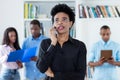 African american businesswoman at phone with group of black business people