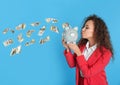 African-American businesswoman with piggy bank on color background. Money saving Royalty Free Stock Photo