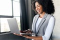 African-American businesswoman uses a laptop in a modern office