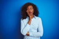 African american businesswoman wearing shirt standing over isolated blue background thinking looking tired and bored with Royalty Free Stock Photo