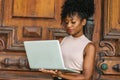 African American Businesswoman working in New York. Young beautiful black woman with afro hairstyle wearing sleeveless light color Royalty Free Stock Photo