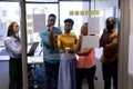 African american businesswoman writing strategy on glass while planning with biracial colleagues Royalty Free Stock Photo