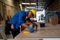 African American carpenter man use tape measure to work with timber on table during work in factory workplace area Royalty Free Stock Photo