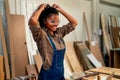 African American carpenter woman stand with setting up her hair and smile during work in wood factory workplace