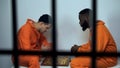 African american and caucasian criminals playing chess in cell, hobby in prison