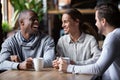 African American and Caucasian friends having fun together in coffeehouse Royalty Free Stock Photo