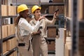 African american and caucasian warehouse operators scanning boxes barcodes