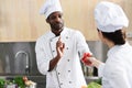 African american chef and female cook sharing cooking ingredients Royalty Free Stock Photo