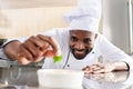 African american chef garnishing dish Royalty Free Stock Photo