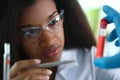 African american chemist holds glass test tube with red liquid solution Royalty Free Stock Photo