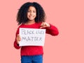 African american child with curly hair holding black lives matter banner pointing finger to one self smiling happy and proud