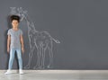 African-American child measuring height near chalk giraffe drawing on grey wall Royalty Free Stock Photo