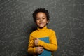 African American child student on blackboard background with science and maths formulas Royalty Free Stock Photo