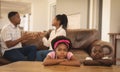 African American children leaning on table while parents arguing on the sofa