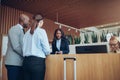 African American concierge checking in two smiling hotel guests Royalty Free Stock Photo