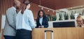 African American concierge checking in two smiling hotel guests Royalty Free Stock Photo