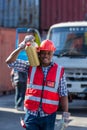 African American Container Warehouse Worker. Foreman carrying oil gallons.