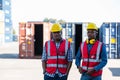 African American Container Warehouse Worker. Foreman control loading Containers box from Cargo freight ship for import export.