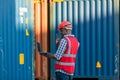 African American Container Warehouse Worker use computer Laptop.