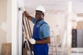 African american contractor plasters the wall indoors Royalty Free Stock Photo