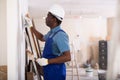 African american contractor plasters the wall indoors Royalty Free Stock Photo